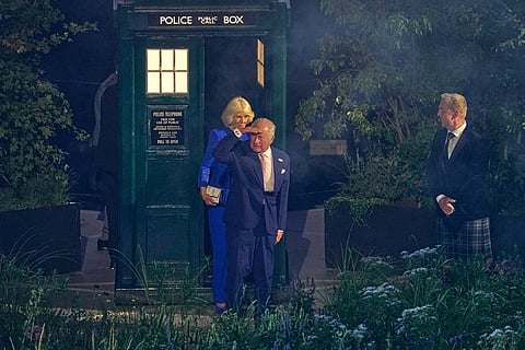 Britain's King Charles III, center, and Queen Camilla look as they step out of the Doctor Who TARDIS police box as Sir Chris Hoy, right, looks on at the start of the Commonwealth Games opening ceremony in Glasgow, Scotland.