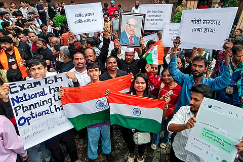 Students and youth activists hold placards and the national tricolour during a protest against the alleged NEET-UG paper leak, at Chhatrapati Shivaji Maharaj Chowk, Vashi, in Navi Mumbai.