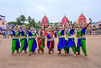 Day In Pics: July 24, 2026 | Photo: PTI : Odissi dancers pose for photographs in front of the chariots of Lord Jagannath, Lord Balabhadra and Goddess Subhadra before the 'Bahuda Yatra', or the return car festival, in Puri, Odisha.