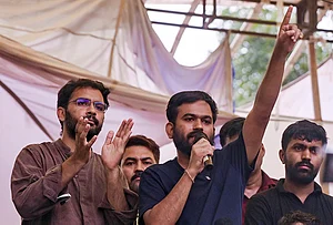 | Photo: PTI : Cockroach Janta Party (CJP) founder Abhijeet Dipke addresses the ongoing protest demanding the resignation of Union Education Minister Dharmendra Pradhan over NEET paper leak issue, at Jantar Mantar, in New Delhi. CJP spokesperson Ashutosh Ranka, left, is also present.