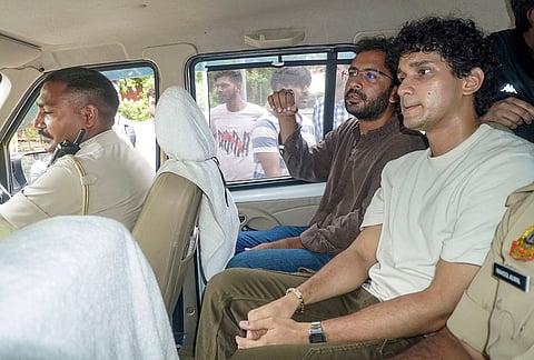 Cockroach Janata Party (CJP) spokespersons Saurav Das and Ashutosh Ranka being escorted by police personnel en route to the Constitution Club of India for a meeting with the Centre over NEET paper leak, in New Delhi.