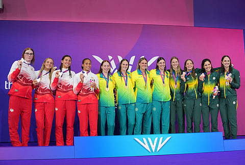 Australia's women's 4x100 meter freestyle relay swimming team centre, with their gold medals, with the England relay team, silver, left and South Africa relay team, bronze pose for the media on the podium during the medal ceremony during the Commonwealth Games in Glasgow, Scotland, Friday, July 24, 2026.