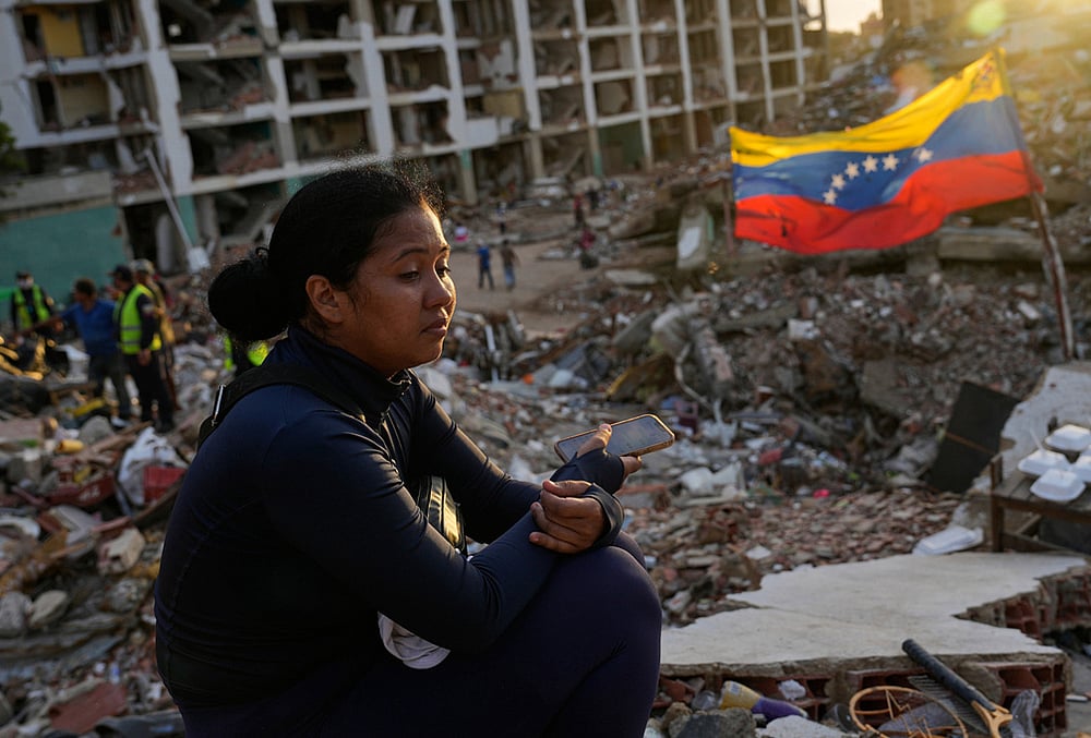 Estefany Landaez sits amid the rubble of a building, waiting to find her two children after the earthquakes in La Guaira, Venezuela, Sunday, July 12, 2026. 
 - | Photo: AP/Ariana Cubillos