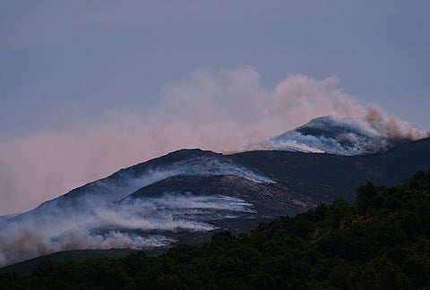 Smoke and flames rise as a wildfire advances near Burgohondo, Ávila province, Spain, Friday, July 24, 2026. 