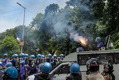 A security official fires tear gas shells to disperse the demonstrators following a chaos that erupted amid the ongoing protest of Cockroach Janta Party (CJP) demanding the resignation of union education Minister Dharmendra Pradhan over the NEET paper leak issue, at Jantar Mantar, in New Delhi, Saturday, July 25, 2026. 