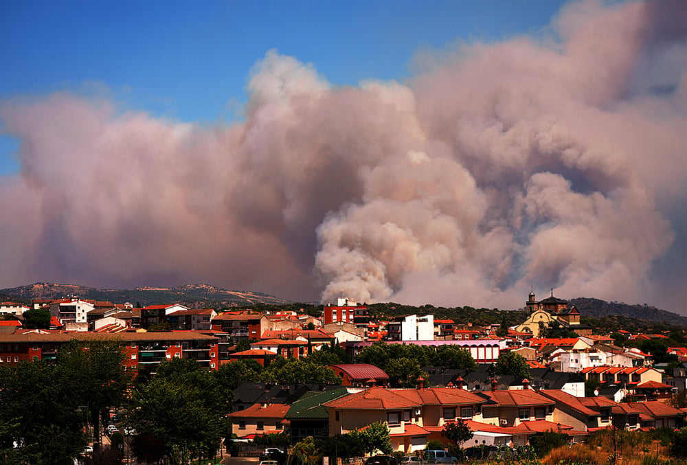 | Photo: AP/Manu Fernandez : Smoke and flames rise as a wildfire advances near La Adrada, Ávila province, Spain, Friday, July 24, 2026. 
