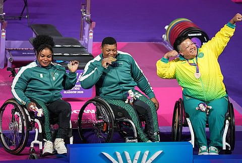 Gold medalist Nigeria's Folashade Oluwafemiayo, center, silver medalist Ferdinand Rita, left, and bronze medalist Australia's Hani Watson celebrate during the medal ceremony for para powerlifting at the Commonwealth Games in Glasgow, Scotland, Friday, July 24, 2026. 