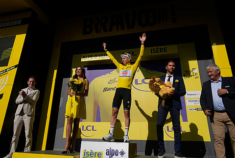 Slovenia's Tadej Pogacar, wearing the overall leader's yellow jersey, celebrates on the podium after winning the nineteenth stage of the Tour de France cycling race with start in Gap and finish in Alpe d'Huez, France, Friday, July 24, 2026. 