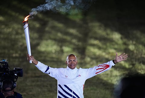 The former Athlete Felix Sanchez, from the Dominican Republic, holds the torch during the opening ceremony of the Central American and Caribbean Games in Santo Domingo, Dominican Republic, Friday, July 24, 2026.