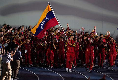 Luis Alvarez of Venezuela carries his country's flag during the opening ceremony of the Central American and Caribbean Games in Santo Domingo, Dominican Republic, Friday, July 24, 2026.