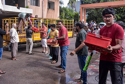 BJP MLA Sandip Desai distributes milk packets to stranded people in a flood-affected area at Parvat Patiya Madhav Baag, in Surat, Gujarat.