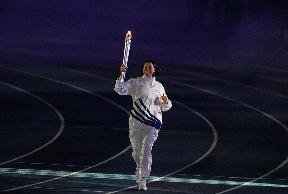 The former volleyball player Milagros Cabral, from the Dominican Republic, carries the torch into the stadium during the opening ceremony of the Central American and Caribbean Games in Santo Domingo, Dominican Republic, Friday, July 24, 2026. 