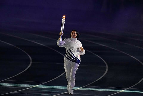 The former volleyball player Milagros Cabral, from the Dominican Republic, carries the torch into the stadium during the opening ceremony of the Central American and Caribbean Games in Santo Domingo, Dominican Republic, Friday, July 24, 2026. 
