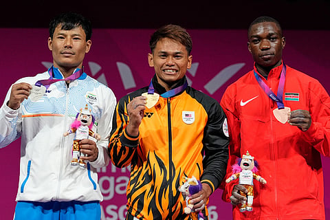 From left, Silver medalist India's Rishikant Chanambam Singh, Gold medalist Malaysia's Kasdan Bin Mohamad Aniq and Bronze medalist Kenya's Joshua Amunga Mboya celebrate after wining medals in 60 kilogram clean and jerk weightlifting during the Commonwealth Games in Glasgow, Scotland.