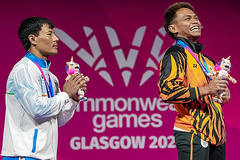 Silver medallist India's Rishikanta Singh, left, and gold medallist Malaysia's Mohamad Aniq Kasdan pose for photographs during the presentation ceremony after the men's 60kg weightlifting competition at the 23rd Commonwealth Games, in Glasgow, Scotland.