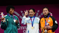 From left, silver medalist Nigeria's Ruth Asuquo Nyong, gold medalist India's Mirabai Chanu and bronze medalist Malaysia's Irene Jane Henry celebrate on the podium for the women's 48 kilogram weightlifting, during the Commonwealth Games in Glasgow, Scotland, Sunday, July 26, 2026. - (AP Photo/Manish Swarup)