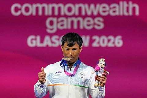 India's Rishikant Chanambam Singh celebrates after wining silver medal in 60 kilogram clean and jerk weightlifting during the Commonwealth Games in Glasgow, Scotland.