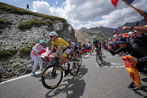 Slovenia's Tadej Pogacar, wearing the overall leader's yellow jersey, climbs the Galibier pass ahead of Belgium's Remco Evenepoel, center, and France's Paul Seixas, right, during the twentieth stage of the Tour de France cycling race with start in Le Bourg d'Oisans and finish in Alpe d'huez, France.