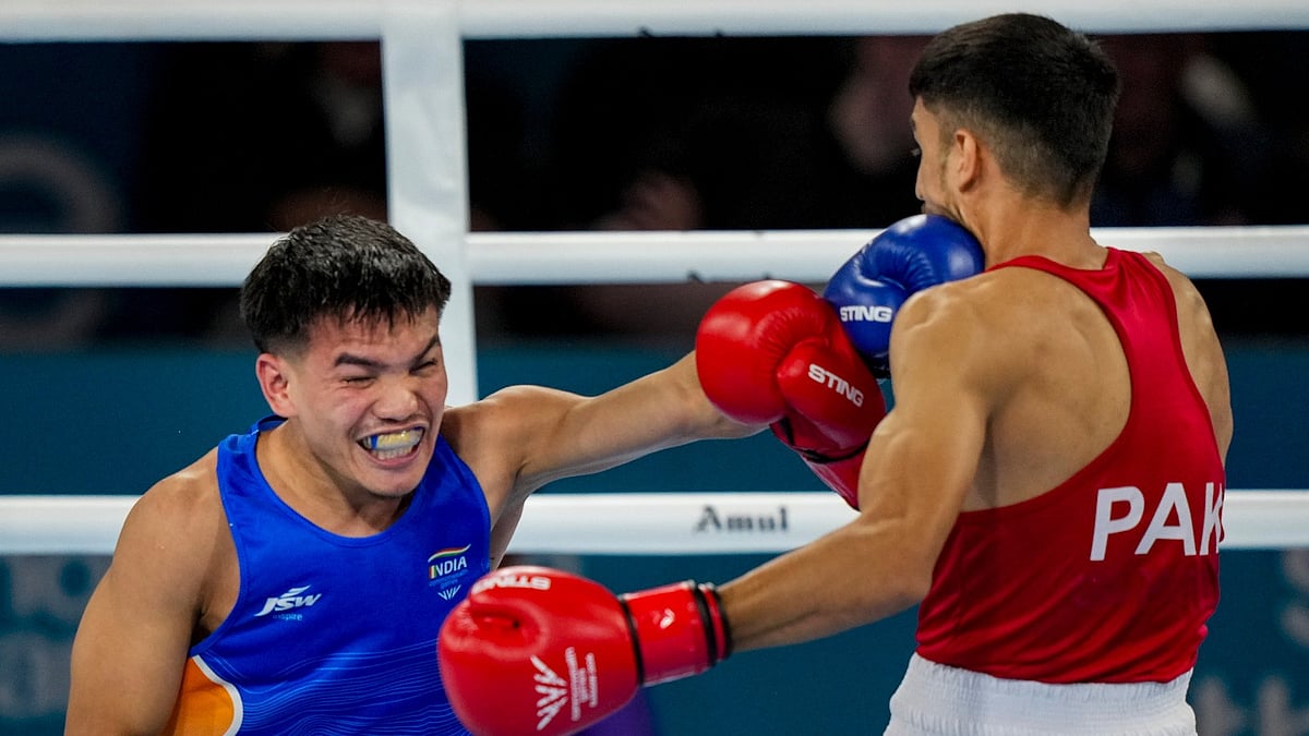 Glasgow: India's Jadumani Singh Mandengbam, blue, competes against Pakistan's Sumama Rehman during the men's 55kg boxing round of 16 at the 23rd Commonwealth Games, in Glasgow. - PTI Photo/Ravi Choudhary