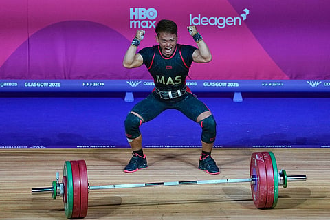 Malaysia's Kasdan Bin Mohamad Aniq celebrates after wining gold medal in 60 kilogram clean and jerk weightlifting during the Commonwealth Games in Glasgow, Scotland.