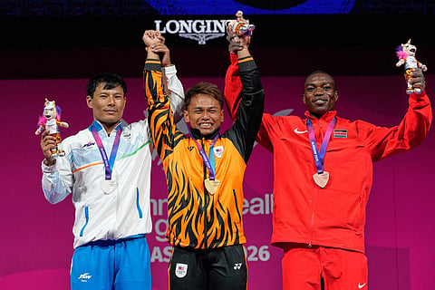 From left, Silver medalist India's Rishikant Chanambam Singh, Gold medalist Malaysia's Kasdan Bin Mohamad Aniq and Bronze medalist Kenya's Joshua Amunga Mboya celebrate after wining medals in 60 kilogram clean and jerk weightlifting during the Commonwealth Games in Glasgow, Scotland.