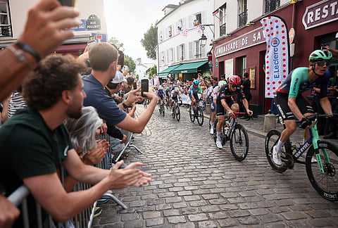 Cyclists race through the cobbled streets of Montmartre during the last stage of the Tour de France cycling race with start and finish in Paris, Sunday, July 26, 2026. 