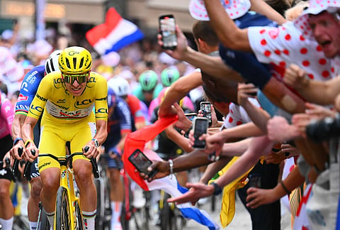 Slovenia's Tadej Pogacar, wearing the overall leader's yellow jersey, races through the cobbled streets of Montmartre during the last stage of the Tour de France cycling race with start and finish in Paris, Sunday, July 26, 2026. 