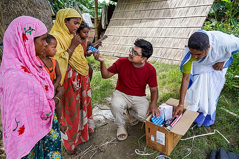 Health officials distribute medicines to residents of a flood-affected area following incessant rain, at Khandahkhati Char in Morigaon, Assam.