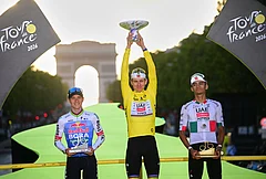 Slovenia's Tadej Pogacar, wearing the overall leader's yellow jersey, celebrates on the podium after winning the Tour de France cycling race alongside Belgium's Remco Evenepoel, second, and Mexico's Isaac Del Toro, third, in Paris, Sunday, July 26, 2026. - | Photo: Bernard Papon/Pool Photo via AP