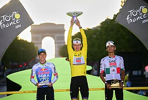 | Photo: Bernard Papon/Pool Photo via AP : Slovenia's Tadej Pogacar, wearing the overall leader's yellow jersey, celebrates on the podium after winning the Tour de France cycling race alongside Belgium's Remco Evenepoel, second, and Mexico's Isaac Del Toro, third, in Paris, Sunday, July 26, 2026.