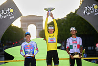 | Photo: Bernard Papon/Pool Photo via AP : Slovenia's Tadej Pogacar, wearing the overall leader's yellow jersey, celebrates on the podium after winning the Tour de France cycling race alongside Belgium's Remco Evenepoel, second, and Mexico's Isaac Del Toro, third, in Paris, Sunday, July 26, 2026. 