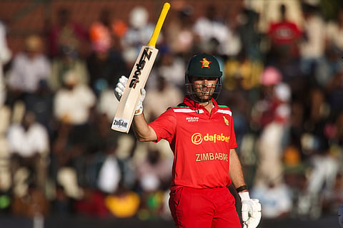 Zimbabwe's batsman Ryan Burl raises his bat after scoring 50 runs during the third T20 cricket match between Zimbabwe and India in Harare, Zimbabwe.