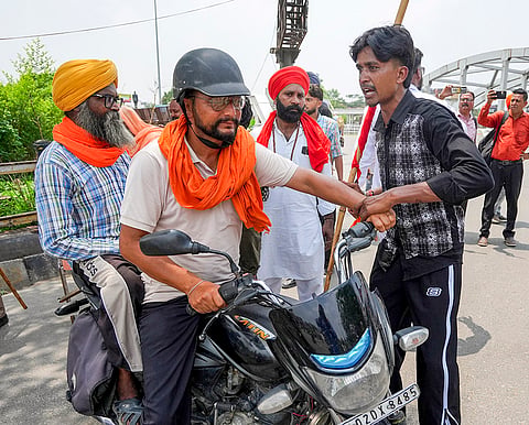 People attempt to stop a commuter as they block Bhandari bridge during the 'Punjab Bandh' called by Valmiki organisations to protest against the baton charge by police on sanitation workers in Barnala, in Amritsar.