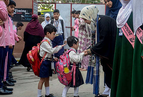 Students arrive at a school to attend classes as educational institutions reopen after the vacation, in Srinagar, Jammu and Kashmir.