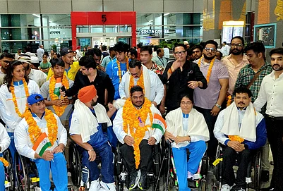 | Photo: PTI : Commonwealth Games 2026 bronze medallist and para powerlifter Jhandu Kumar, front centre, arrives at Indira Gandhi International Airport, in New Delhi.
