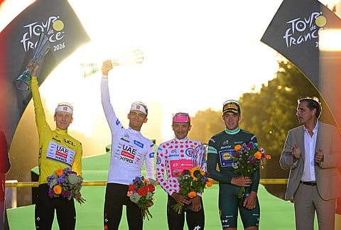 Slovenia's Tadej Pogacar, wearing the overall leader's yellow jersey, celebrates on the podium after winning the Tour de France cycling race with Mexico's Isaac Del Toro, Ecuador's Richard Carapaz and Denmark's Mads Pedersen in Paris, Sunday, July 26, 2026.
