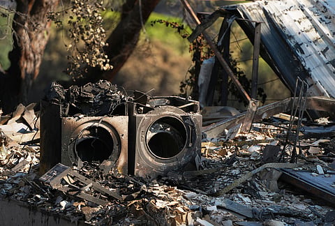 Charred belongings of residents who fled their homes because of the threat of a wildfire are photographed in Navas del Rey, Madrid province, Spain, Monday, July 27, 2026. 