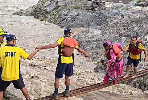 SDRF personnel rescue women trapped in the swollen Mandakini river after a sudden rise in the water level, at Tilwara, in Rudraprayag district, Uttarakhand.