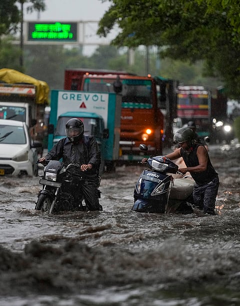 Vehicles move through a waterlogged road amid heavy rain, in the ITO area, New Delhi, Tuesday, July 28, 2026. 