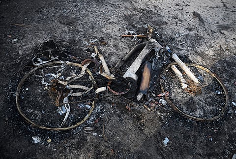 A bicycle lays charred on the ground at a campsite after wildfires raged in Lège-Cap-Ferret, outside Bordeaux, France, Monday, July 27, 2026.