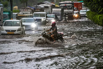 | Photo: PTI/Salman Ali : Vehicles move through a waterlogged road amid heavy rain, in the ITO area, New Delhi, Tuesday, July 28, 2026. IMD issued an orange alert in the national capital for the next few hours.