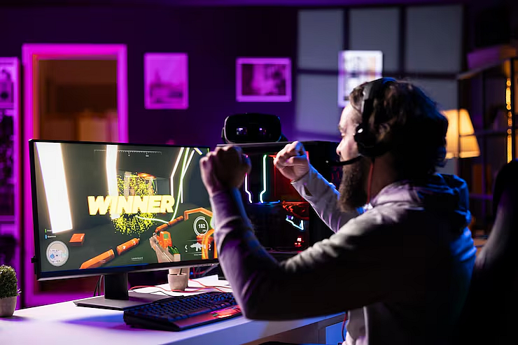 A gamer celebrating a victory in front of his PC screen