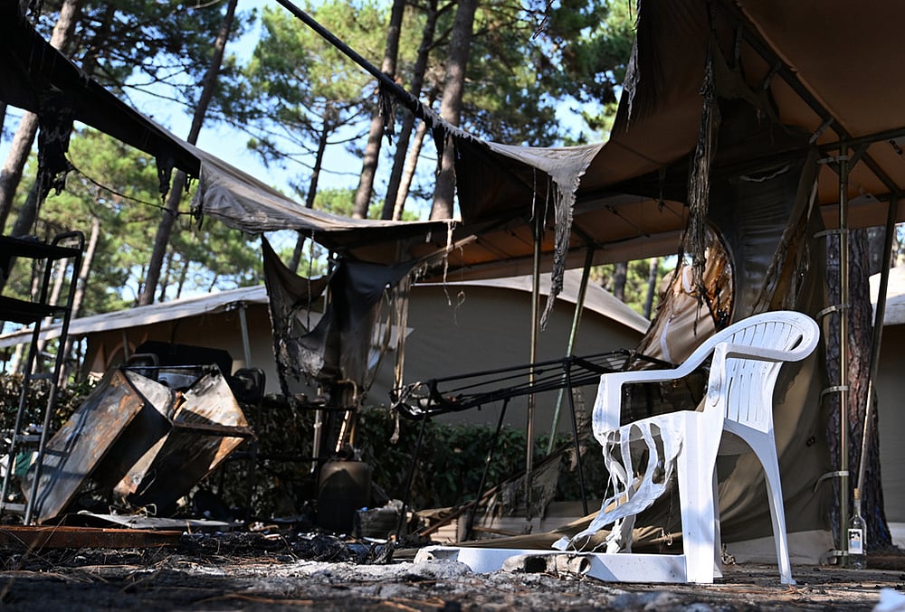 A plastic chair is partially melted and a tent burned at a campsite in Lège-Cap-Ferret after wildfires raged outside Bordeaux, France, Monday, July 27, 2026.  - | Photo: AP/Emma Da Silva