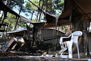 | Photo: AP/Emma Da Silva : A plastic chair is partially melted and a tent burned at a campsite in Lège-Cap-Ferret after wildfires raged outside Bordeaux, France, Monday, July 27, 2026.