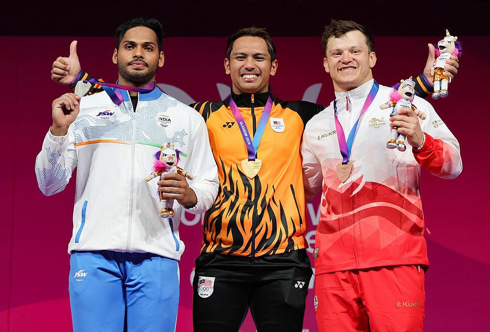 | Photo: Steve Welsh/PA via AP : Erry Hidayat Muhammad of Malaysia with his gold medal alongside Valluri Ajaya Babu of India with his silver medal, left, and Chris Murray of England with his bronze medal, right, after the Men's 79kg weightlifting competition during the Commonwealth Games in Glasgow, Scotland, Monday, July 27, 2026. 
