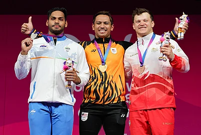 | Photo: Steve Welsh/PA via AP : Erry Hidayat Muhammad of Malaysia with his gold medal alongside Valluri Ajaya Babu of India with his silver medal, left, and Chris Murray of England with his bronze medal, right, after the Mens 79kg weightlifting competition during the Commonwealth Games in Glasgow, Scotland, Monday, July 27, 2026.