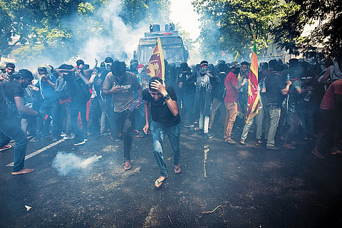 Public Unrest: Protesters run for cover as soldiers fire tear gas during a protest in Colombo on July 13, 2022