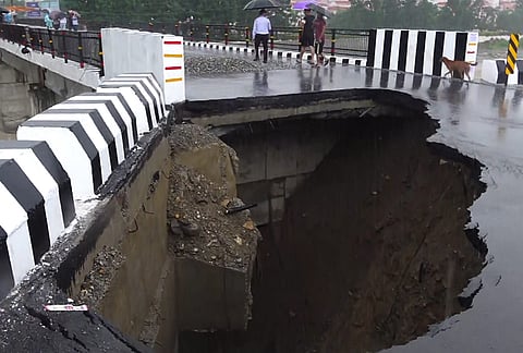 A portion of a road caves in following heavy rainfall, in Dehradun, Uttarakhand.