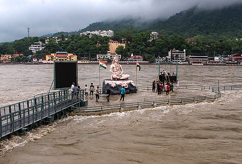 People gather on a portion of the Parmarth Niketan Ghat that remains above water amid rising water levels following rainfall in Rishikesh, Uttarakhand.