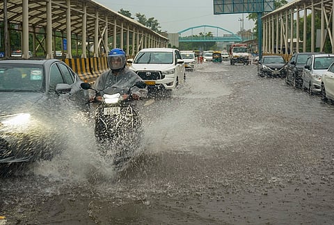 Commuters wade through a waterlogged Mathura road near Bharat Mandapam following heavy rainfall, in New Delhi, Tuesday, July 28, 2026. India Meteorological Department (IMD) forecast a generally cloudy sky with heavy rain for the rest of the day, warning of thunderstorms accompanied by lightning and intense spells of rain across the national capital. 